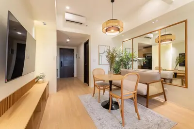 a dining room and living room with a table and chairs at Luxury 1 BR City View in Park Mckinley West Fast Wi-Fi Washer Dryer in Manila