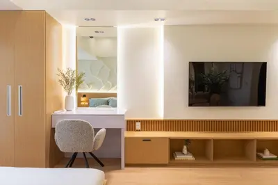 a bedroom with a tv and a chair in a room at Luxury 1 BR City View in Park Mckinley West Fast Wi-Fi Washer Dryer in Manila