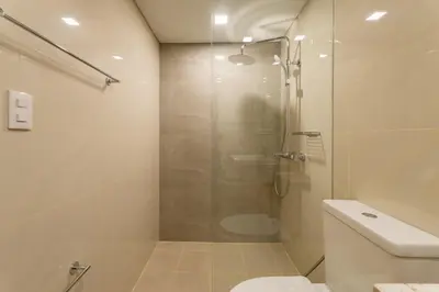 a bathroom with a shower with a toilet and a sink at Luxury 1 BR City View in Park Mckinley West Fast Wi-Fi Washer Dryer in Manila