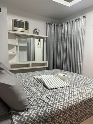 a bedroom with a bed with a microwave on it at JFS Home at Birch Tower 1BR in Manila
