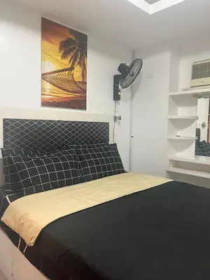 a bedroom with a bed with a black headboard at JFS Home at Birch Tower 1BR in Manila