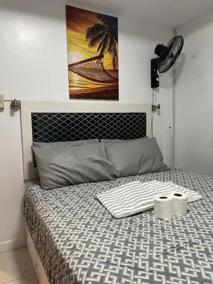 a bedroom with a bed with a poster on the wall at JFS Home at Birch Tower 1BR in Manila
