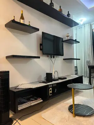 a computer desk with a keyboard and a monitor on a wall at JFS Home at Birch Tower 1BR in Manila