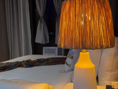 a lamp sitting on a table next to a bed at Hidden Village at Gramercy Residences - APARTMENT with Infinity Pool Sauna Gym in Manila