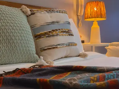 a bed with a pillow and a blanket and a lamp at Hidden Village at Gramercy Residences - APARTMENT with Infinity Pool Sauna Gym in Manila