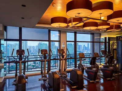 a gym with a view of the city at Hidden Village at Gramercy Residences - APARTMENT with Infinity Pool Sauna Gym in Manila