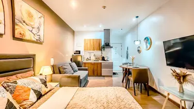 a living room with a couch and a dining room at Gramercy Makati Studio with Free Pool Gym and Sauna in Manila