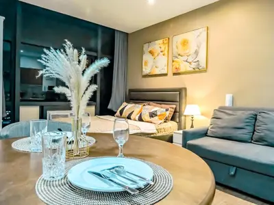 a living room with a table and a couch at Gramercy Makati Studio with Free Pool Gym and Sauna in Manila