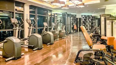 a gym with a row of treadmills and machines at Gramercy Makati Studio with Free Pool Gym and Sauna in Manila