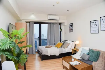 a living room with a bed and a couch at Vue Urbain Moderne - Knightsbridge Poblacion Makati Studio in Manila