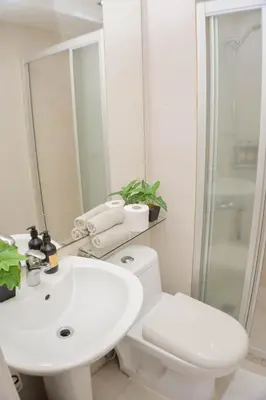 a bathroom with a white toilet and a sink at Vue Urbain Moderne - Knightsbridge Poblacion Makati Studio in Manila