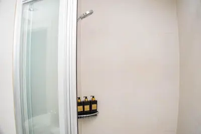 a bathroom with three bottles of wine in a shower at Vue Urbain Moderne - Knightsbridge Poblacion Makati Studio in Manila