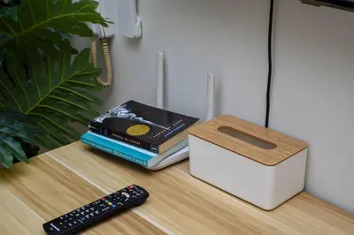 a stack of books next to a box and a remote control at Vue Urbain Moderne - Knightsbridge Poblacion Makati Studio in Manila