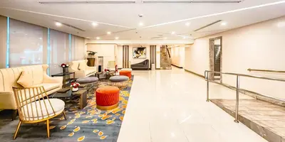 a lobby with a waiting area with chairs and tables at Central Makati Studio with Gym Pool and Massage Room in Manila