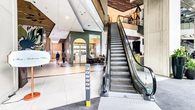 a staircase in a shopping mall with a sign in the middle at Central Makati Studio with Gym Pool and Massage Room in Manila