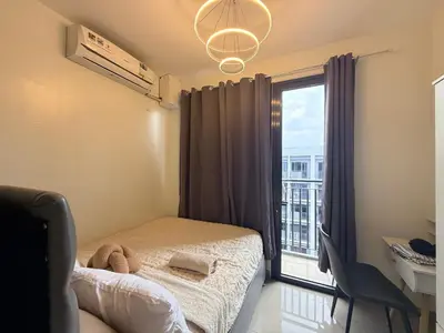 a bedroom with a bed and a large window at Affordable Stay at Shore Residence near MOA by VCA Staycation in Manila