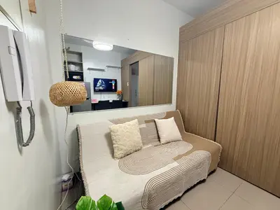a small room with a chair and a mirror at Affordable Stay at Shore Residence near MOA by VCA Staycation in Manila