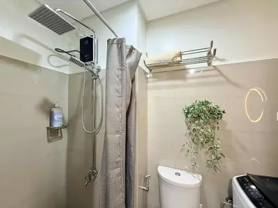 a bathroom with a shower and a toilet in it at Affordable Stay at Shore Residence near MOA by VCA Staycation in Manila