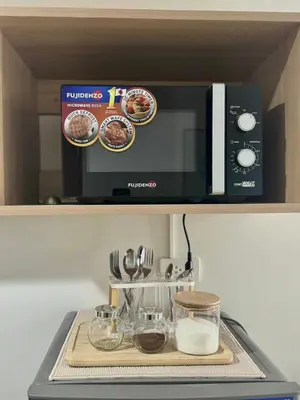 a microwave sitting on top of a kitchen counter at Cozy 1-Bedroom Staycation near NAIA & Mall of Asia in Manila