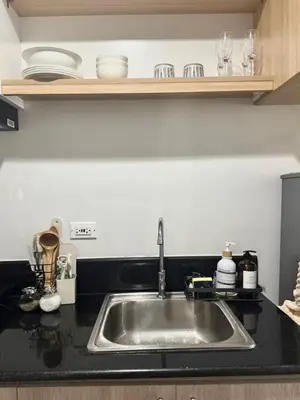 a kitchen counter with a sink in a kitchen at Cozy 1-Bedroom Staycation near NAIA & Mall of Asia in Manila