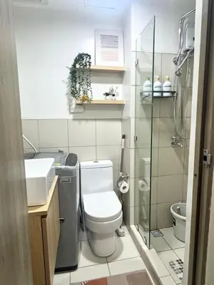 a bathroom with a toilet and a glass shower at Cozy 1-Bedroom Staycation near NAIA & Mall of Asia in Manila
