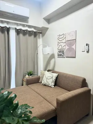 a living room with a couch and a lamp at Cozy 1-Bedroom Staycation near NAIA & Mall of Asia in Manila