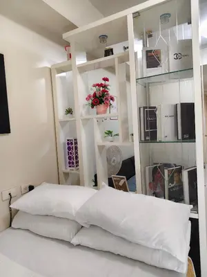 a bedroom with a white bed with white shelves at Sea Residences Staycation SMDC Property in Manila