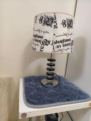 a lamp on a table with a blue pillow at Sea Residences Staycation SMDC Property in Manila