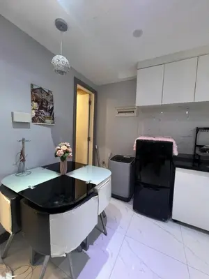 a kitchen with white cabinets and a table with flowers on it at Apartment 1BR Condo Manila- Suntrust Adriatico Gardens Malate in Manila