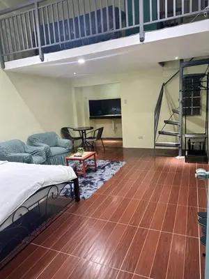 a room with a bed and a couch and a table at SJ Vistacation in Tanza