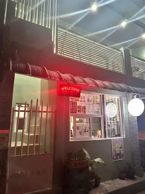 a restaurant with a red sign on the front of it at SJ Vistacation in Tanza