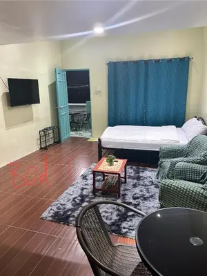 a room with a bed and a couch and a table at SJ Vistacation in Tanza