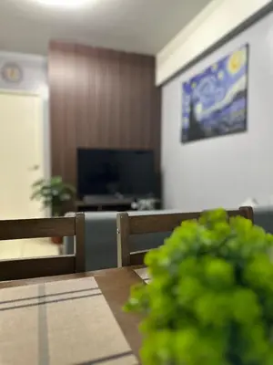 a dining room with a table and a television at Ezras Place Modern Condo with City views in Manila