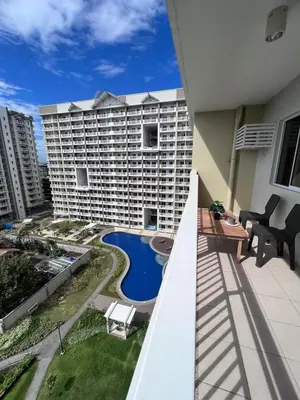 a balcony view of a large apartment building with a swimming pool at Ezras Place Modern Condo with City views in Manila