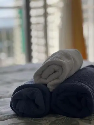 a pile of towels sitting on top of a bed at Ezras Place Modern Condo with City views in Manila