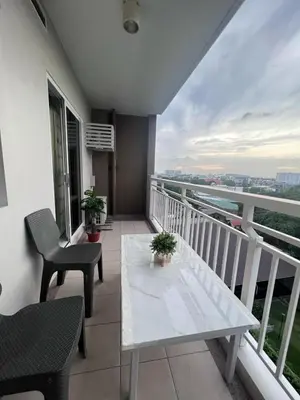 a balcony with a white table and chairs at Ezras Place Modern Condo with City views in Manila