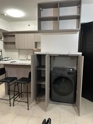 a kitchen with a washing machine under a counter at Cypress Towers Staycation in Manila