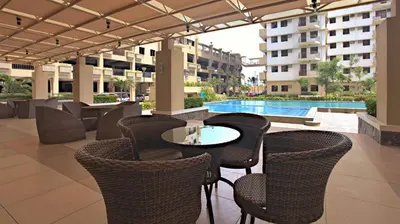 a patio with chairs and a table and a pool at Cypress Towers Staycation in Manila
