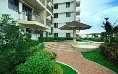 a brick walkway with an umbrella in front of a building at Cypress Towers Staycation in Manila