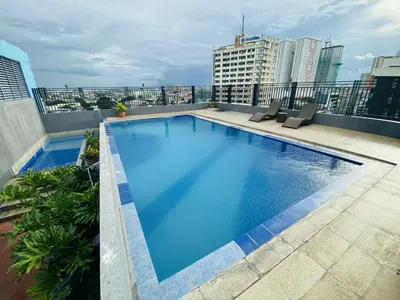 a large swimming pool on the roof of a building at Affordable makati 908 deluxe in Manila