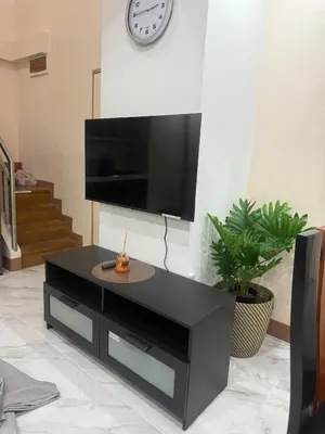 a black coffee table in a living room with a clock at Affordable makati 908 deluxe in Manila