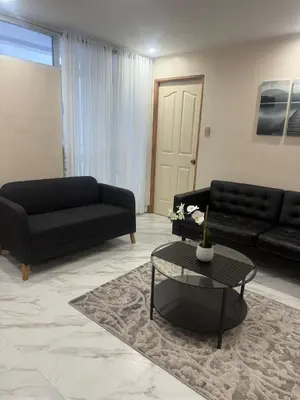 a living room with a black couch and a table at Affordable makati 908 deluxe in Manila