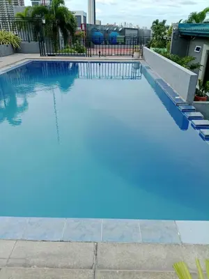 a swimming pool with blue water in a building at Affordable makati 908 deluxe in Manila