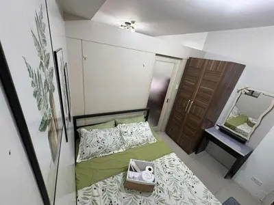 a small bedroom with a bed and a mirror at Allie's Cozy Place at Sea Residences in Manila