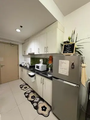 a kitchen with a refrigerator and a kitchen floor with panda faces on it at Allie's Cozy Place at Sea Residences in Manila