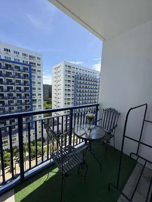a balcony with a table and chairs on a balcony at Allie's Cozy Place at Sea Residences in Manila