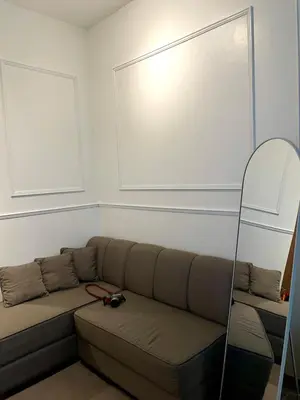 a living room with a couch and a mirror at Lush Urban Studio in Manila