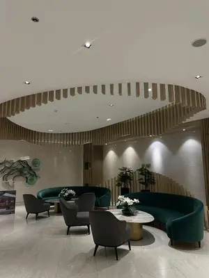 a lobby with green couches and tables and chairs at Lush Urban Studio in Manila
