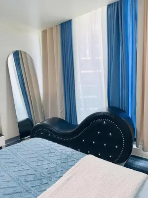 a bedroom with a bed and a window with blue curtains at Azure staycation By Icay in Manila