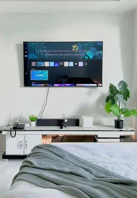 a tv hanging on a wall above a bed at Azure staycation By Icay in Manila